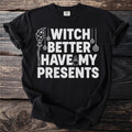 Black t-shirt with white text "WITCH BETTER HAVE MY PRESENTS" and witchy graphics.