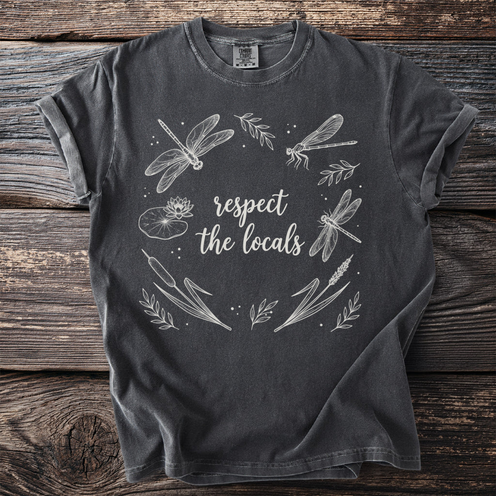 Charcoal t-shirt featuring a circular design of dragonflies, cattails, and water lilies with text "respect the locals".
