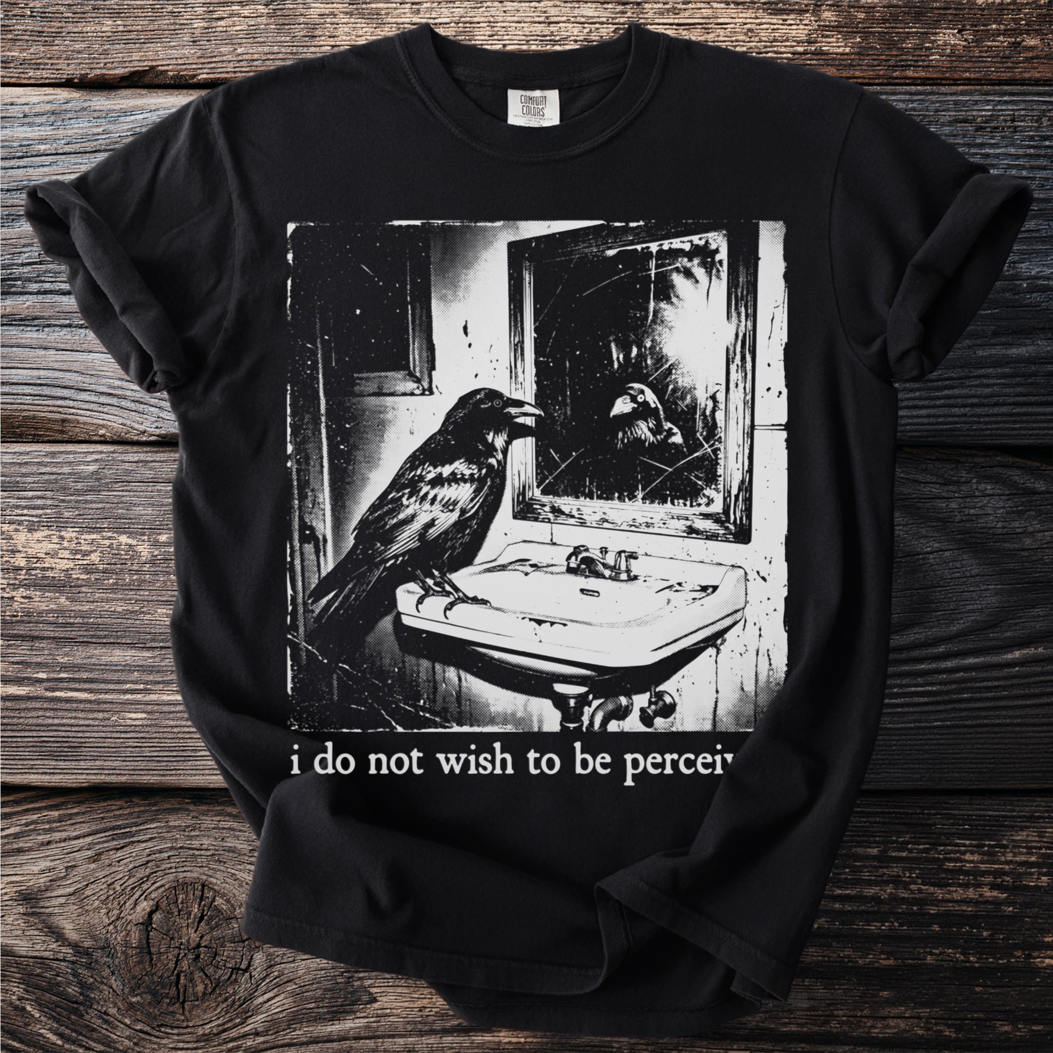 Black t-shirt with graphic of raven at sink and "i do not wish to be percei" text.