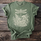 Green t-shirt with cream dragonfly, mushroom, and foliage graphic.