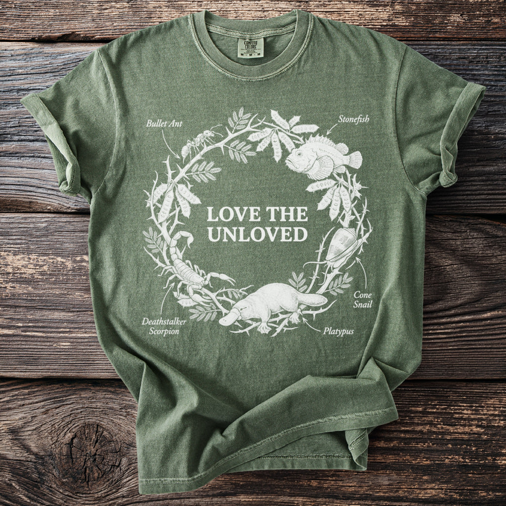 Green t-shirt with white line art of animals and text "Love the Unloved."
