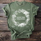 Green t-shirt with white line art of animals and text "Love the Unloved."