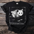 Black T shirt with an opossum and the text “non perceivable creature”.