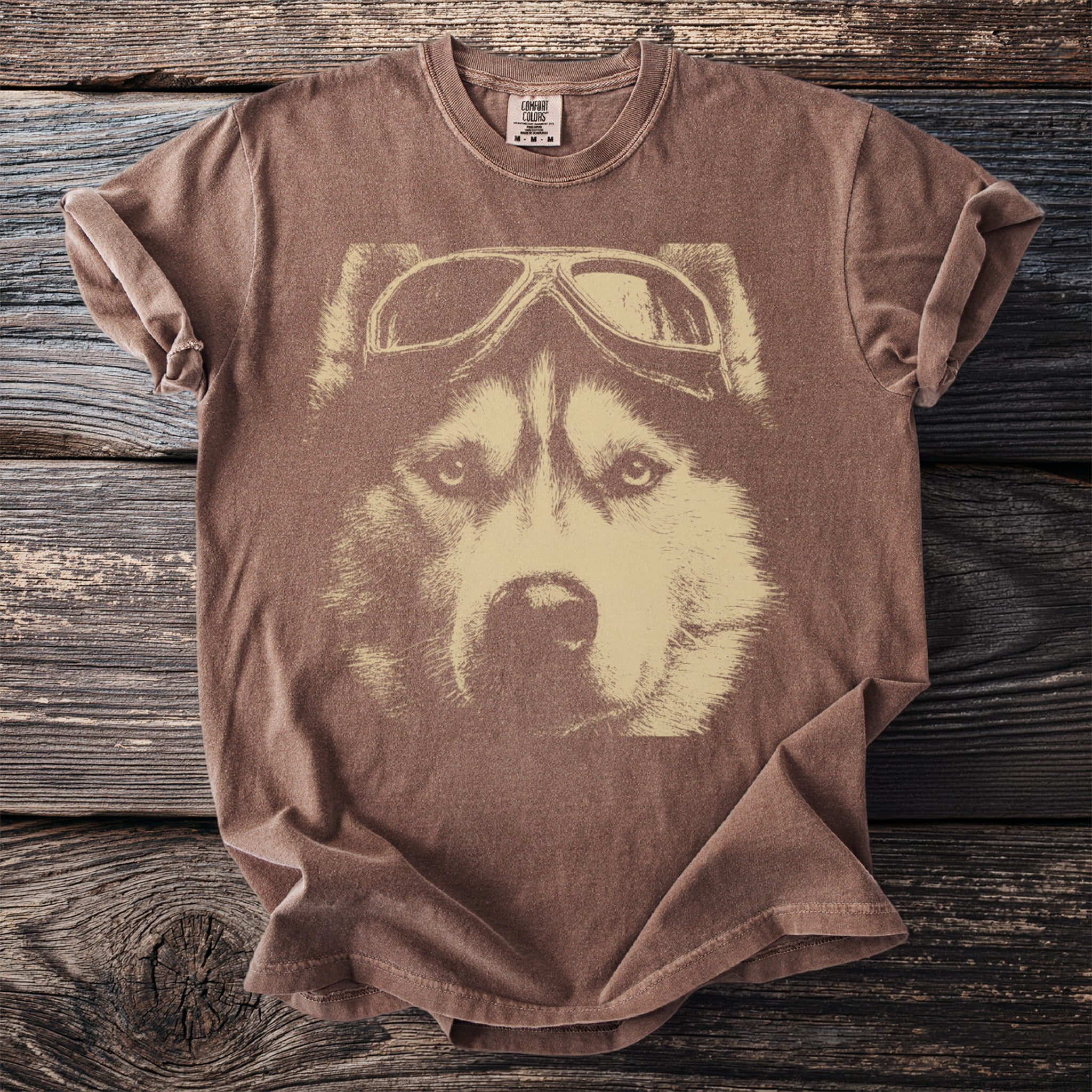Brown t-shirt with a vintage print of a husky wearing aviator goggles.