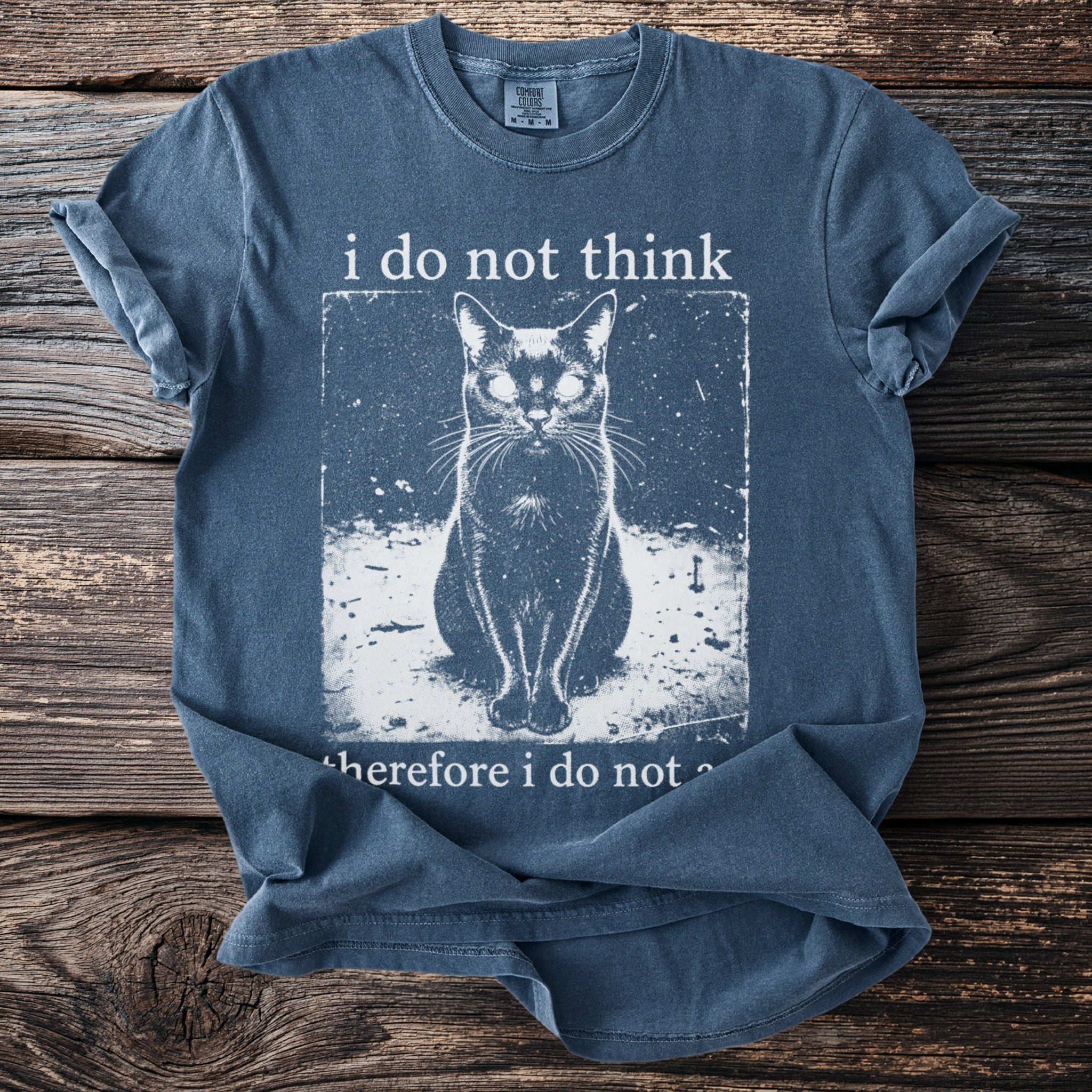 Blue t-shirt with graphic of a cat and text "i do not think therefore i do not".