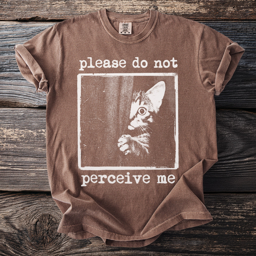 Brown t-shirt with a kitten graphic and the text "please do not perceive me."