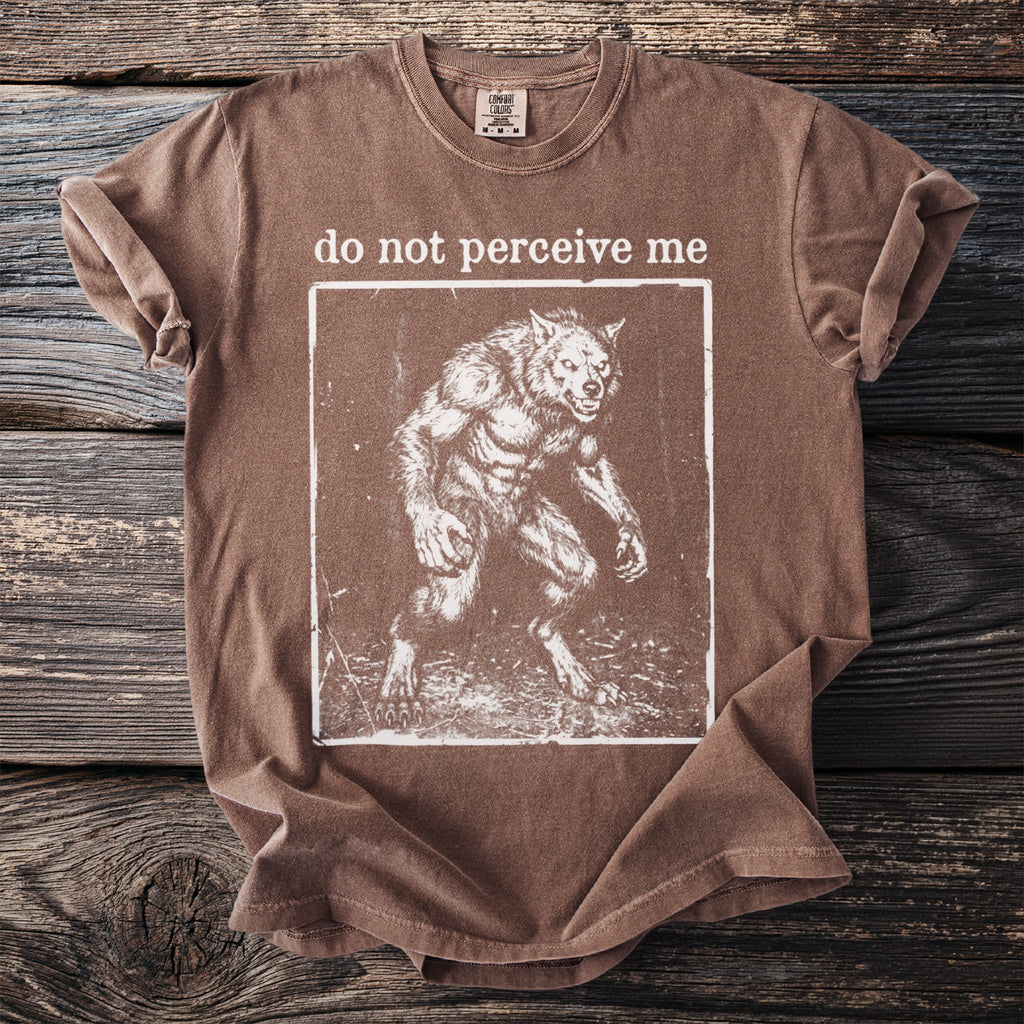 Brown t-shirt with a square graphic of a werewolf and text that reads "do not perceive me".