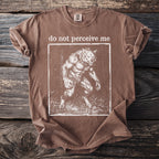 Brown t-shirt with a square graphic of a werewolf and text that reads "do not perceive me".