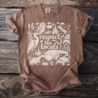 Brown t-shirt with white graphic of "respect the locals" and local wildlife.