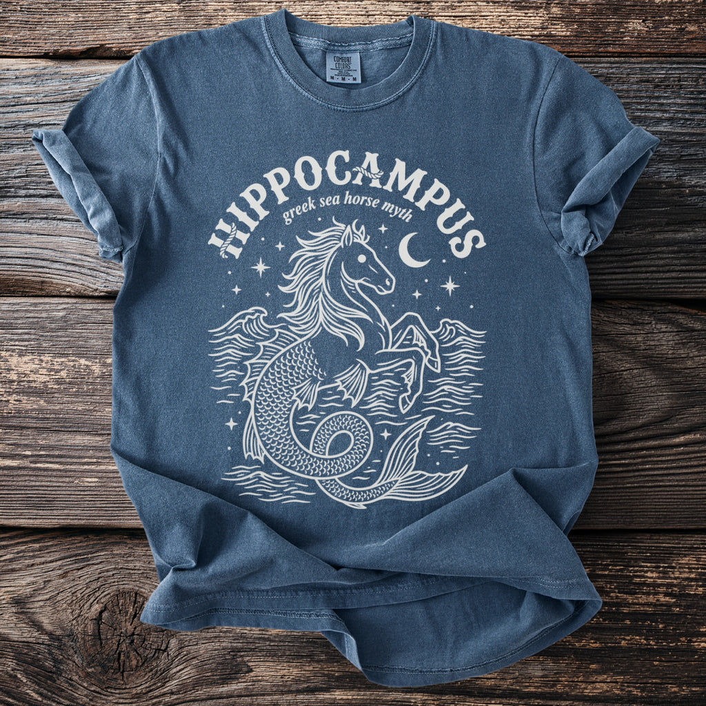 Blue t-shirt with white line art of a hippocampus, waves, moon, and stars.