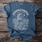 Blue t-shirt with white line art of a hippocampus, waves, moon, and stars.