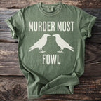 Olive t-shirt with white text "Murder Most Fowl" and silhouette of two crows.