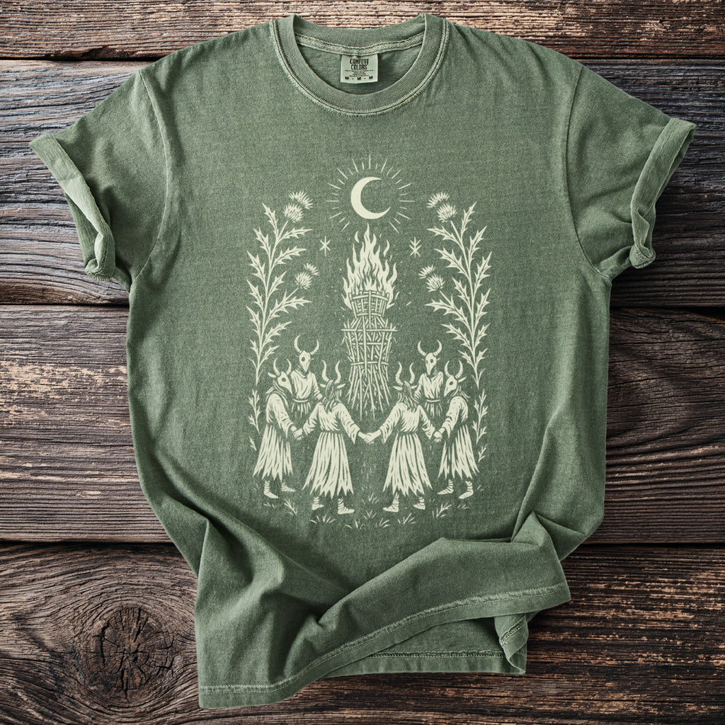 Green t-shirt with a cream graphic of figures in a circle around a bonfire.