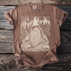 Brown t-shirt with a cream graphic of a wizard, wolves, eagles, and trees.