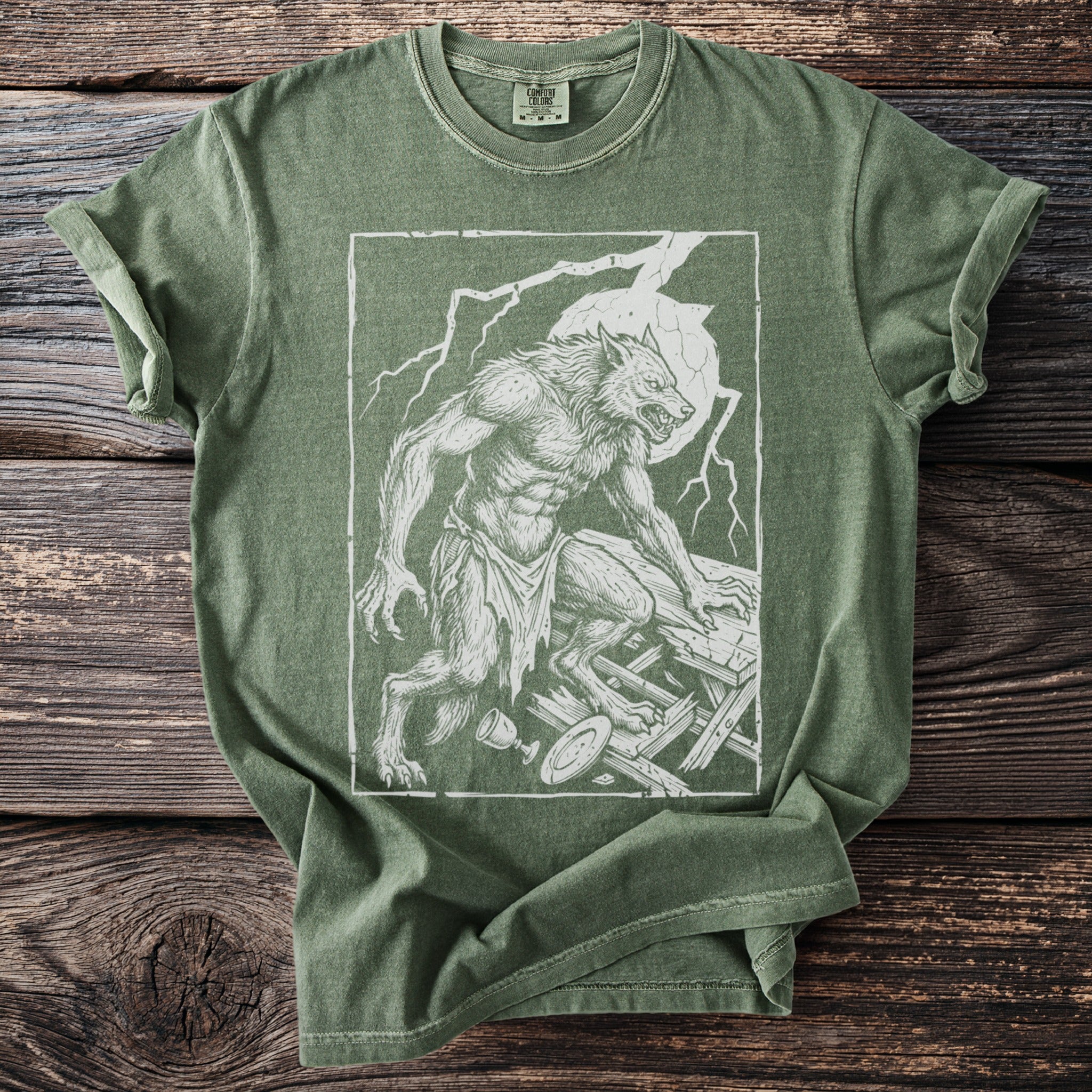 Green t-shirt with a distressed white line drawing of a werewolf on broken wooden planks.