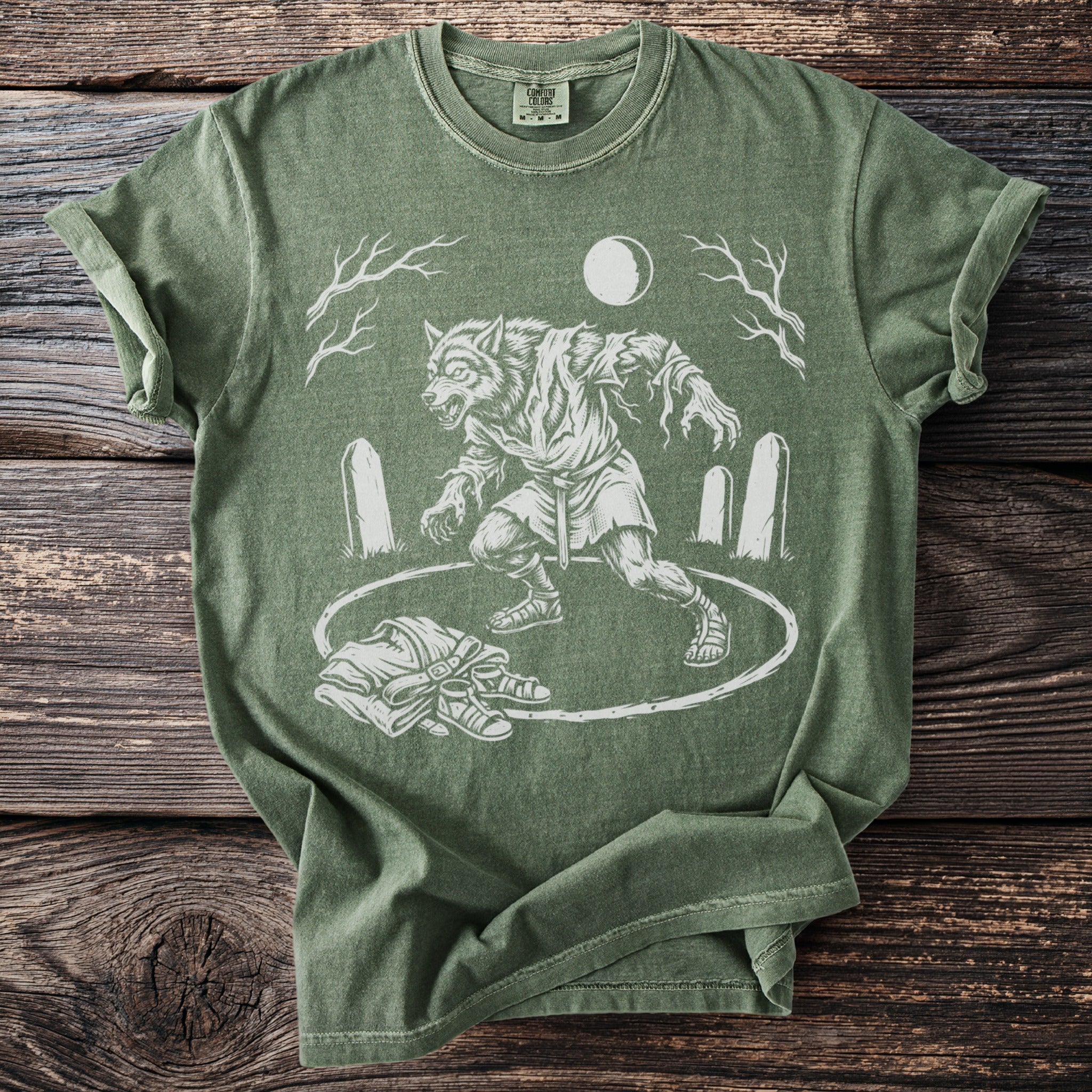 Green t-shirt with a white werewolf graphic under a full moon and bare trees.