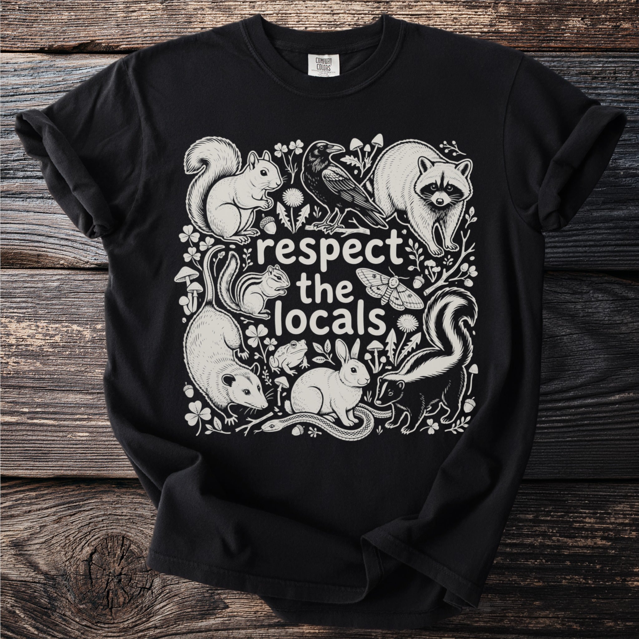 Black t-shirt with "respect the locals" and illustrated animals: squirrel, raccoon, skunk, opossum, rabbit, snake, frog, moth, and crow.