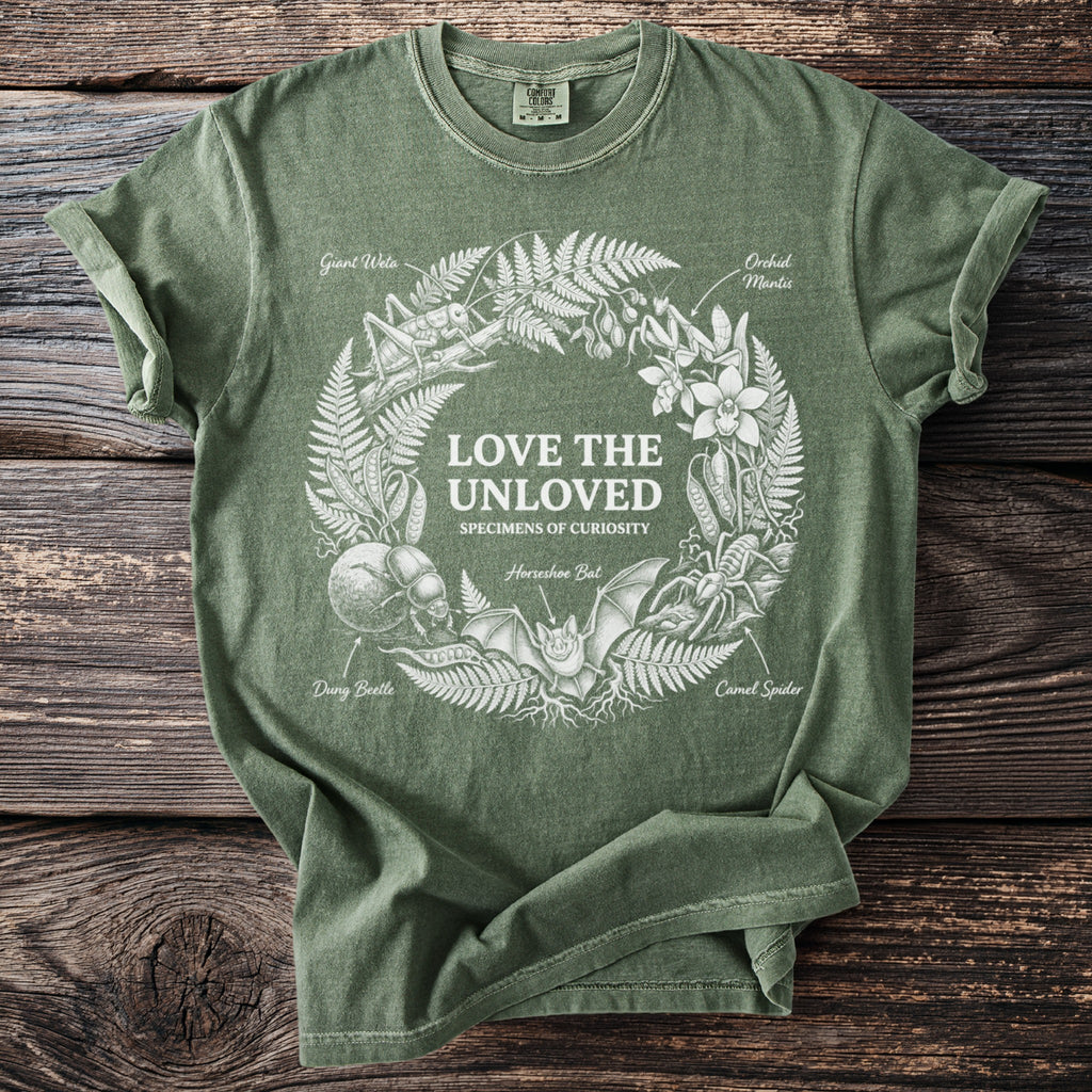 Green t-shirt with white graphic of "Love the Unloved" and various creatures.