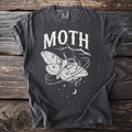 Dark grey t-shirt with white moth and lantern graphic and text "MOTH".