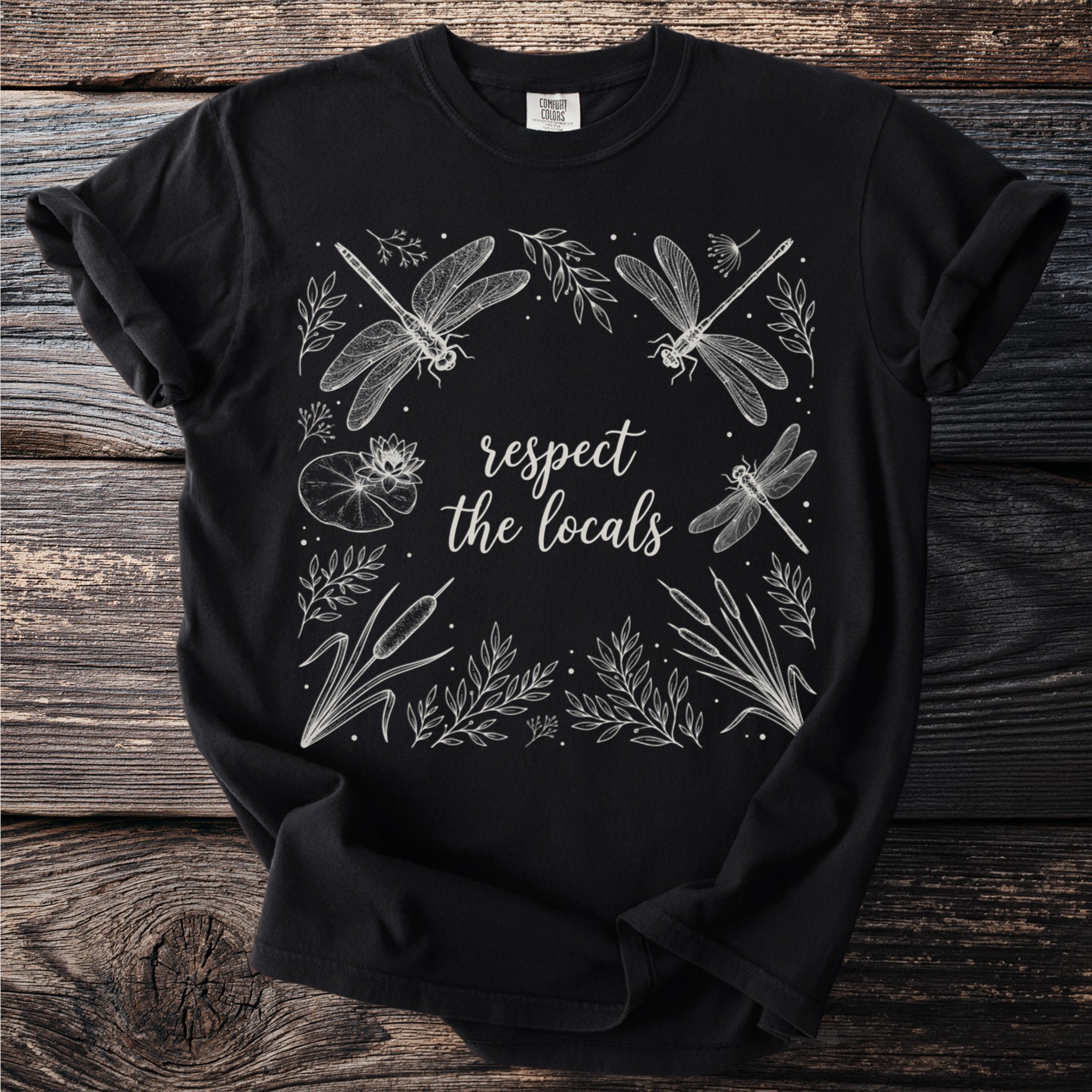 Black t-shirt with white line art of dragonflies and plants, reads "respect the locals".