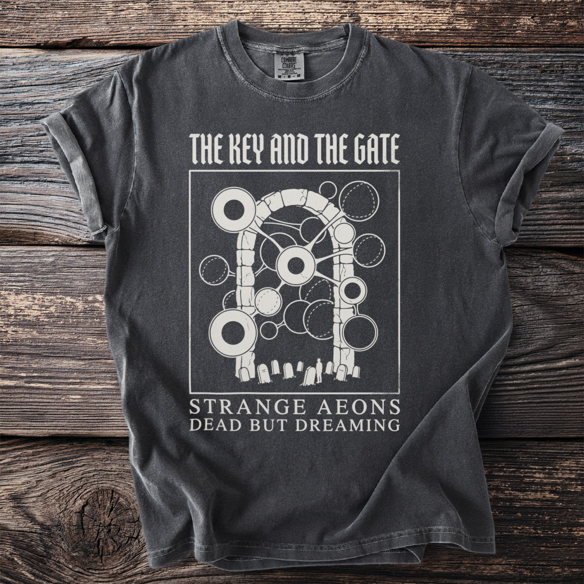Dark gray t-shirt with "The Key and the Gate" text and graphic of a gate over gravestones.