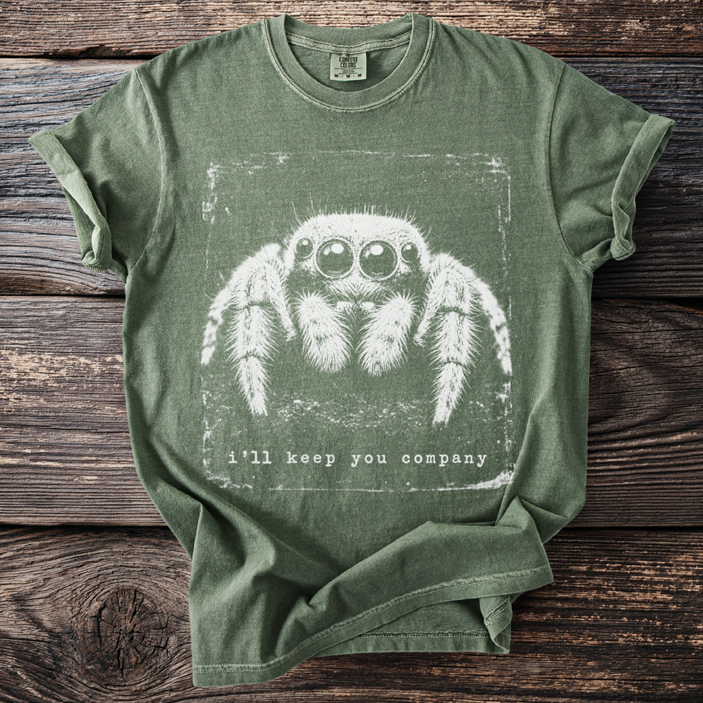 Green t-shirt with a white graphic of a spider and the text "i'll keep you company."