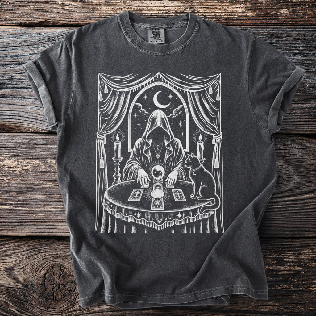 Dark grey t-shirt with white mystical illustration of a cloaked figure with crystal ball.