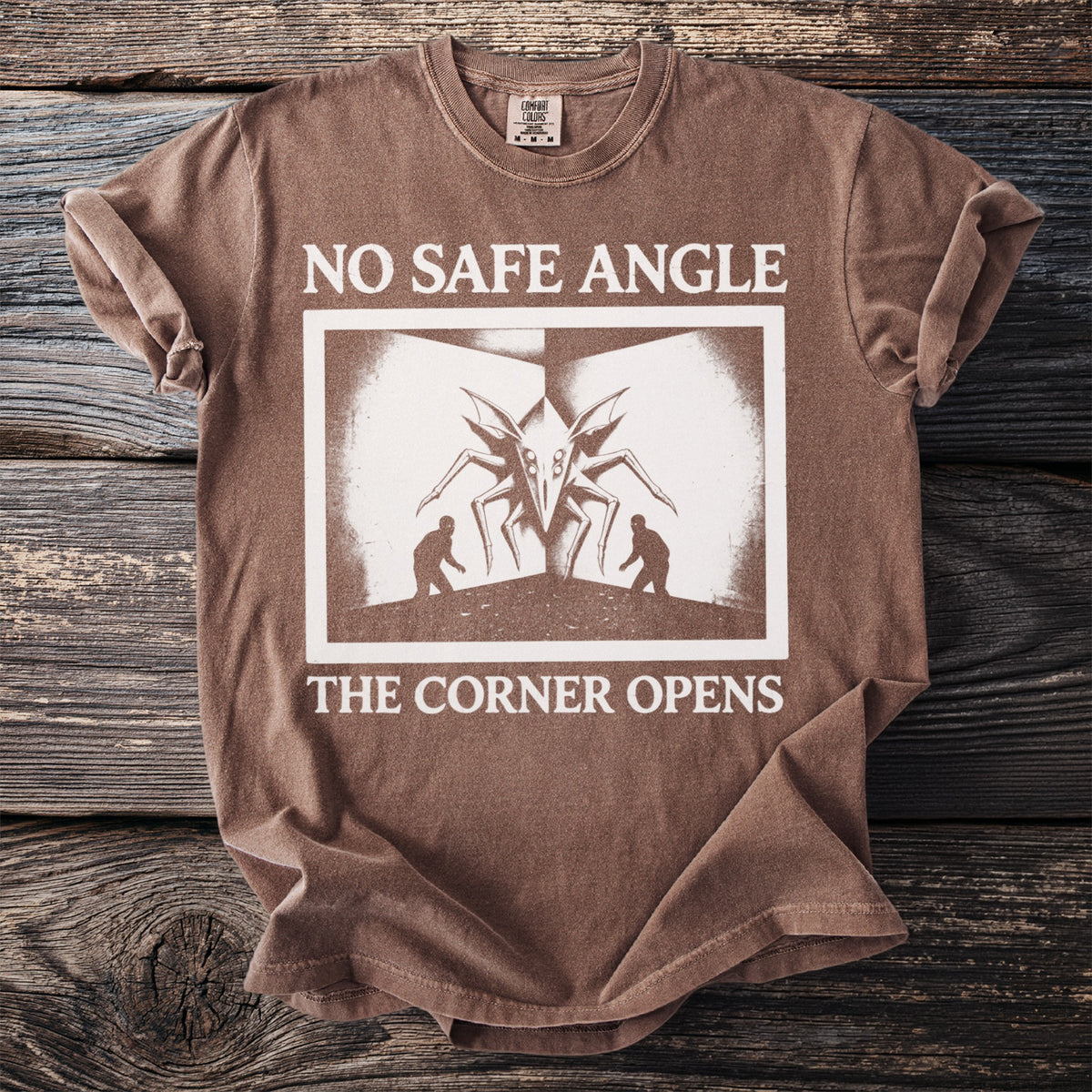 Brown t-shirt with "NO SAFE ANGLE THE CORNER OPENS" text and graphic.
