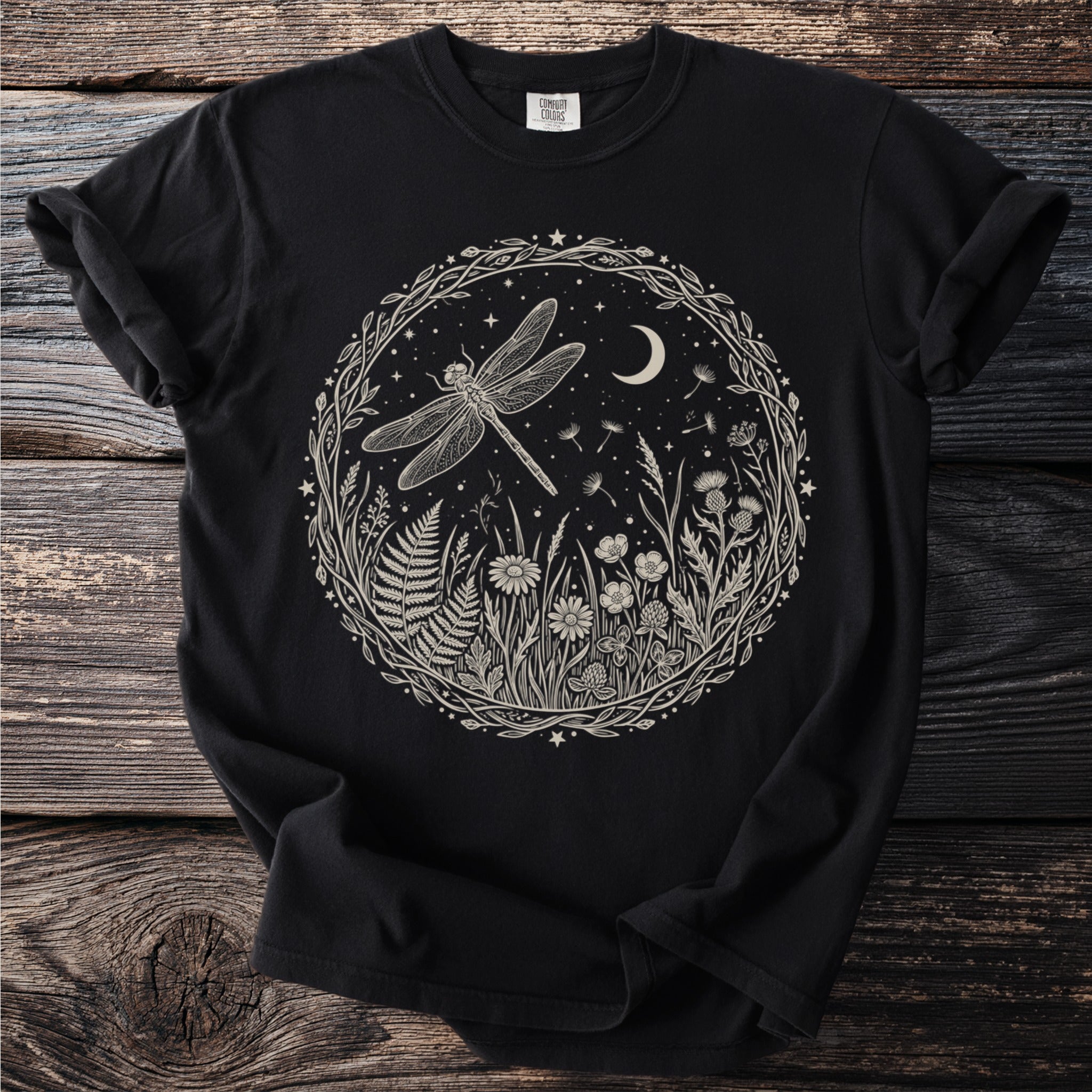 Black t-shirt with circular natural scene featuring a dragonfly, moon, and flowers.