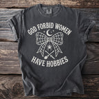 Dark t-shirt with "God forbid women have hobbies" text and spooky graphics.