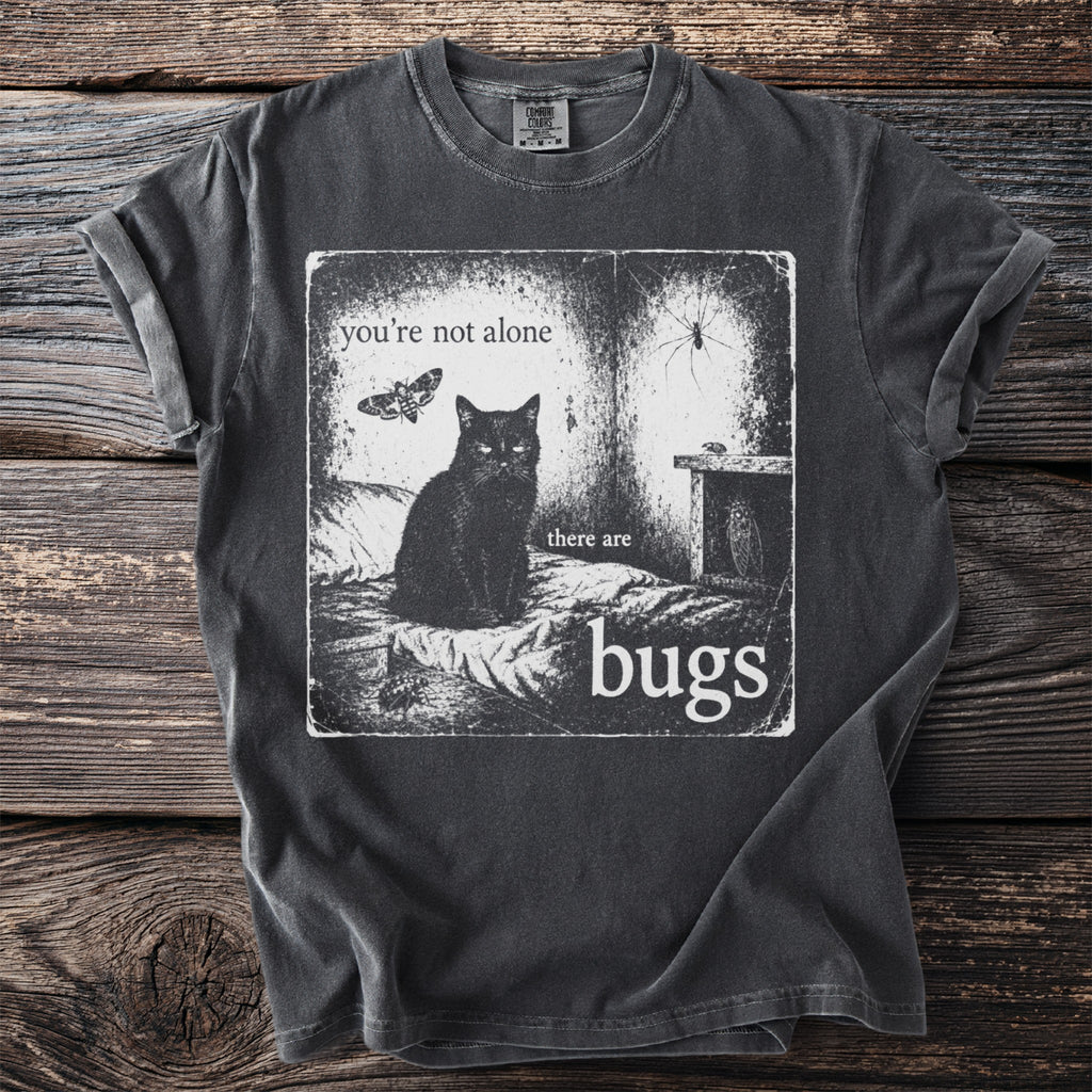 Black t-shirt with graphic of cat, moth, spider, and text "you're not alone there are bugs".