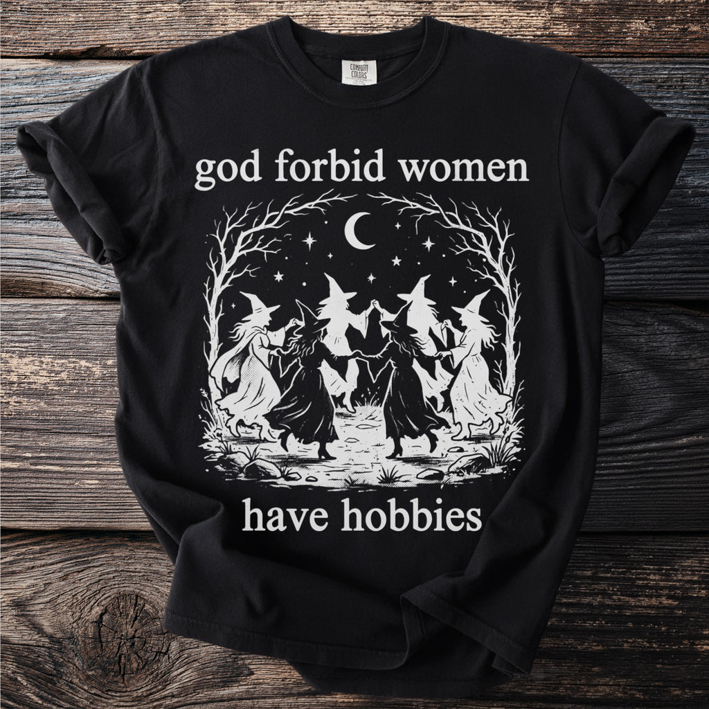 Black t-shirt with "god forbid women have hobbies" and a witch coven illustration.