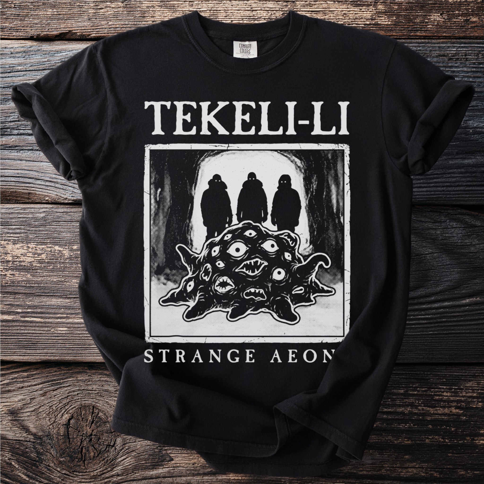 Black t-shirt with "TEKELI-LI STRANGE AEON" and creature with eyes design.
