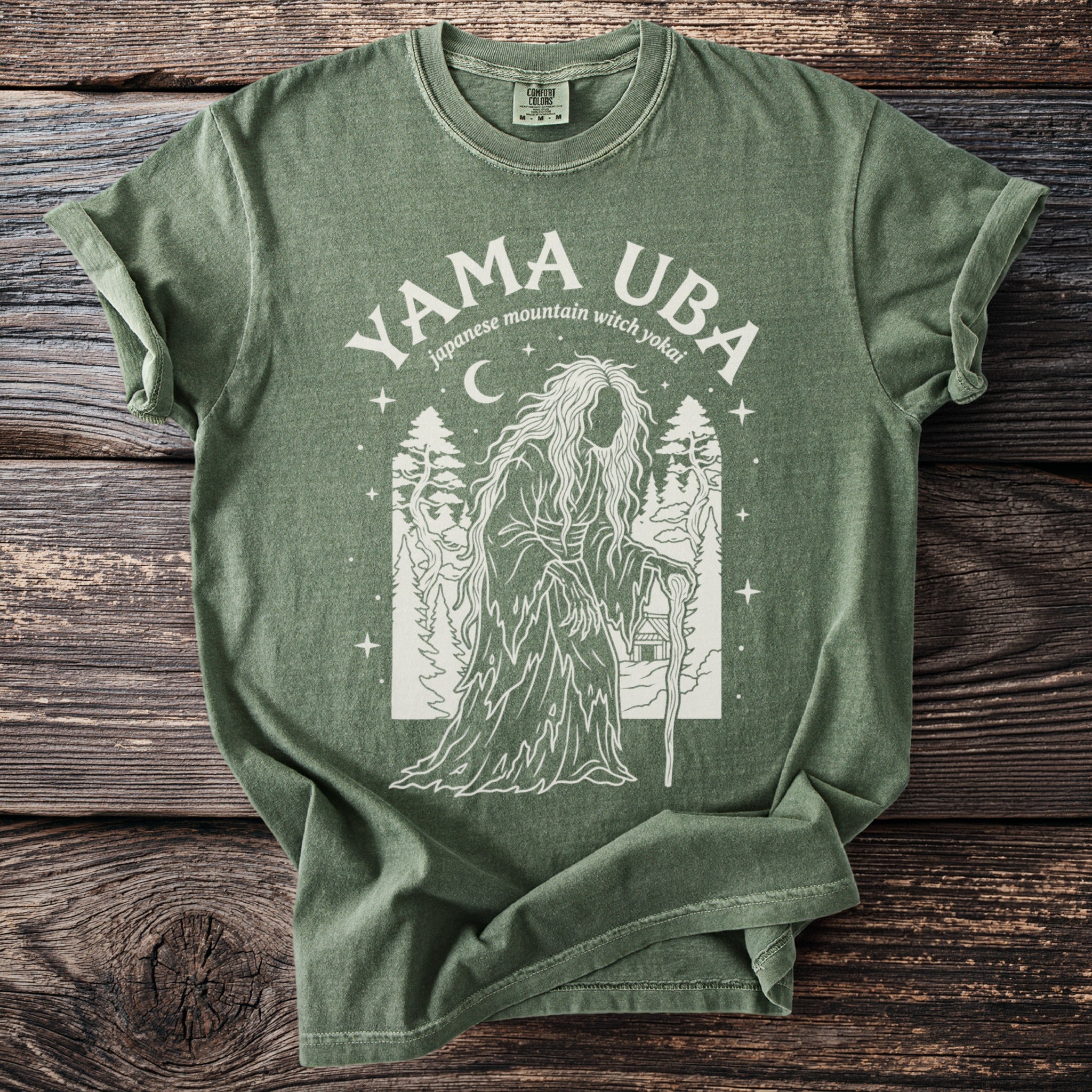 Green t-shirt with white graphic of Yama Uba, Japanese mountain witch yokai, and trees.