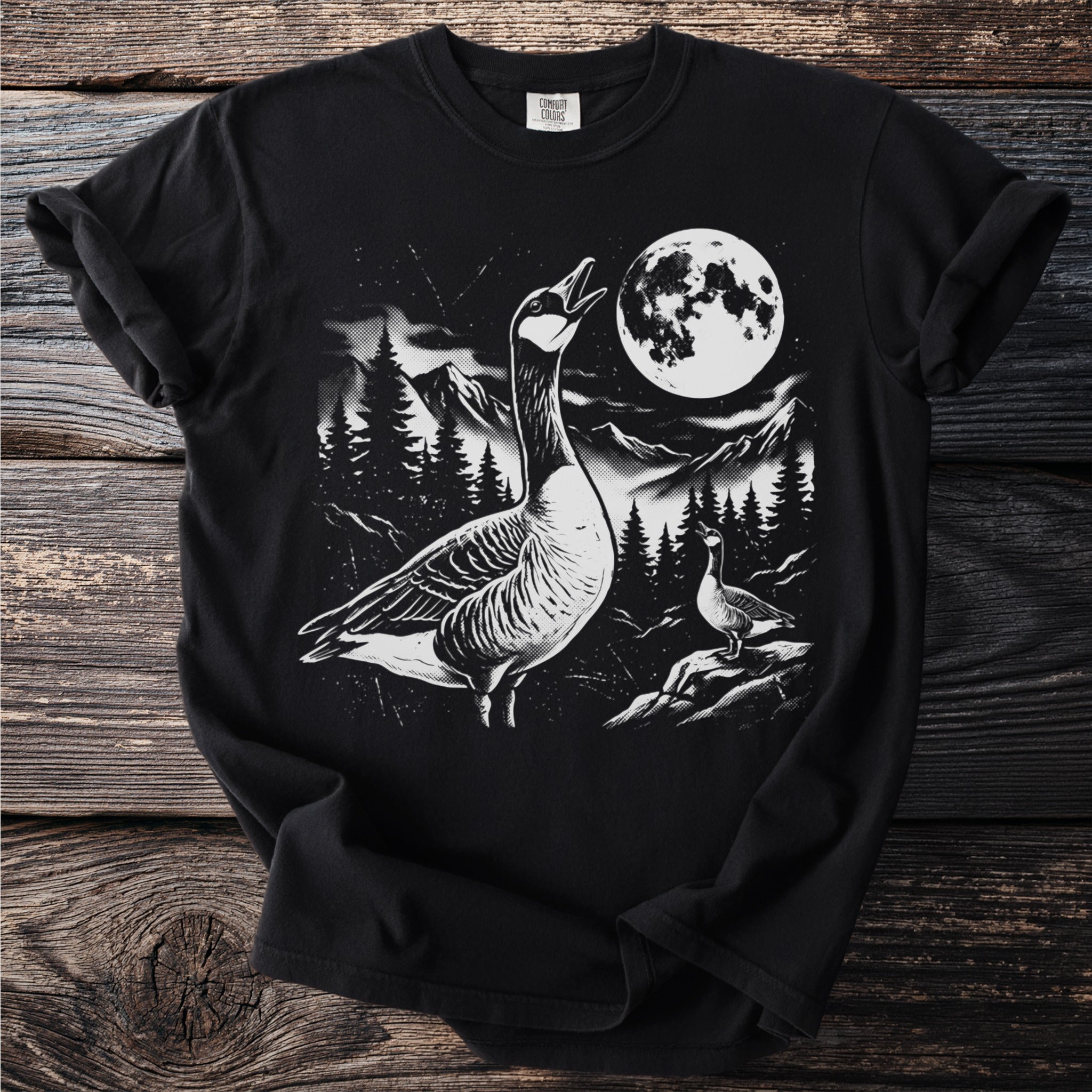 Black t-shirt with a graphic of two geese at night with a moon and mountains.