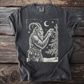 Pepper gray t-shirt with a cream folk-cut print: Krampus hangs one glass ornament on a snowy fir, chains and bells at his waist.