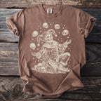 Skeleton jester juggling skulls with stars on a brown t-shirt.