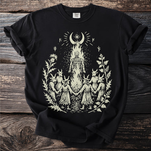 Black t-shirt with a burning wicker figure encircled by participants in goat masks, with a crescent and star above.