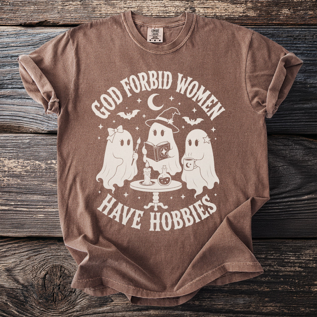 Brown t-shirt with "God forbid women have hobbies" graphic featuring three ghosts.