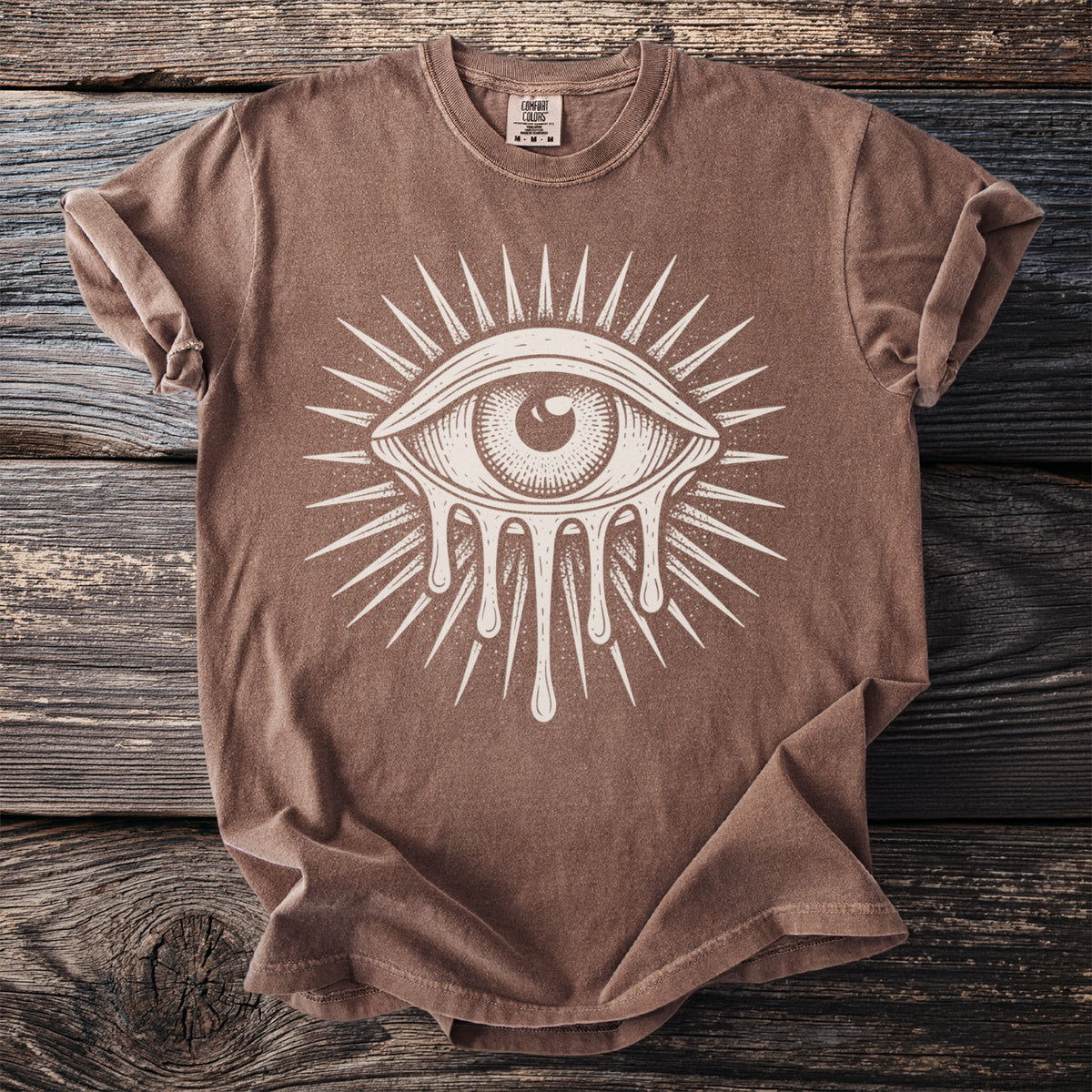 Brown t-shirt with a white dripping eye and sunburst graphic.