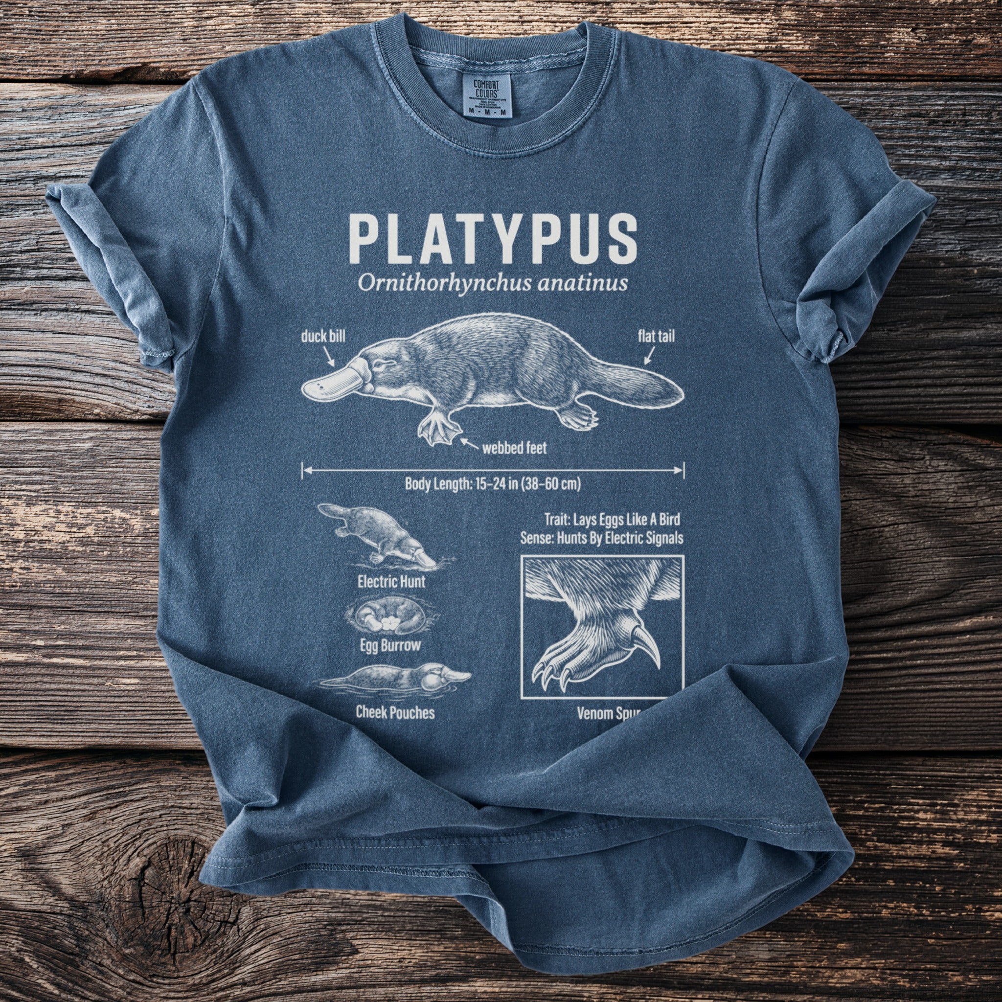 Blue t-shirt with Platypus anatomy diagram, including labels for duck bill, flat tail, and venom spur.