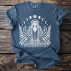 Blue t-shirt with white graphic of a goddess surrounded by moon phases and foliage.