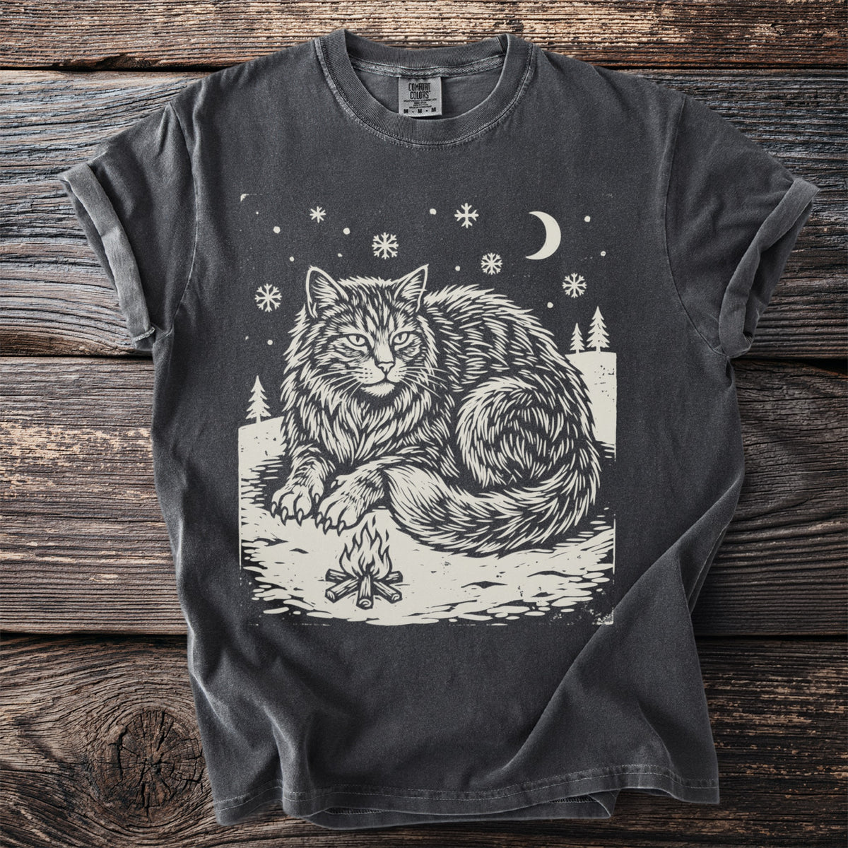 Pepper gray t-shirt with a cream folk-cut print: the enormous Yule Cat lies in the snow beside a small campfire, staring straight ahead.