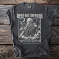 Dark grey t-shirt with a tentacled creature, ship, and text: Dead But Dreaming, Sunken City Sessions.