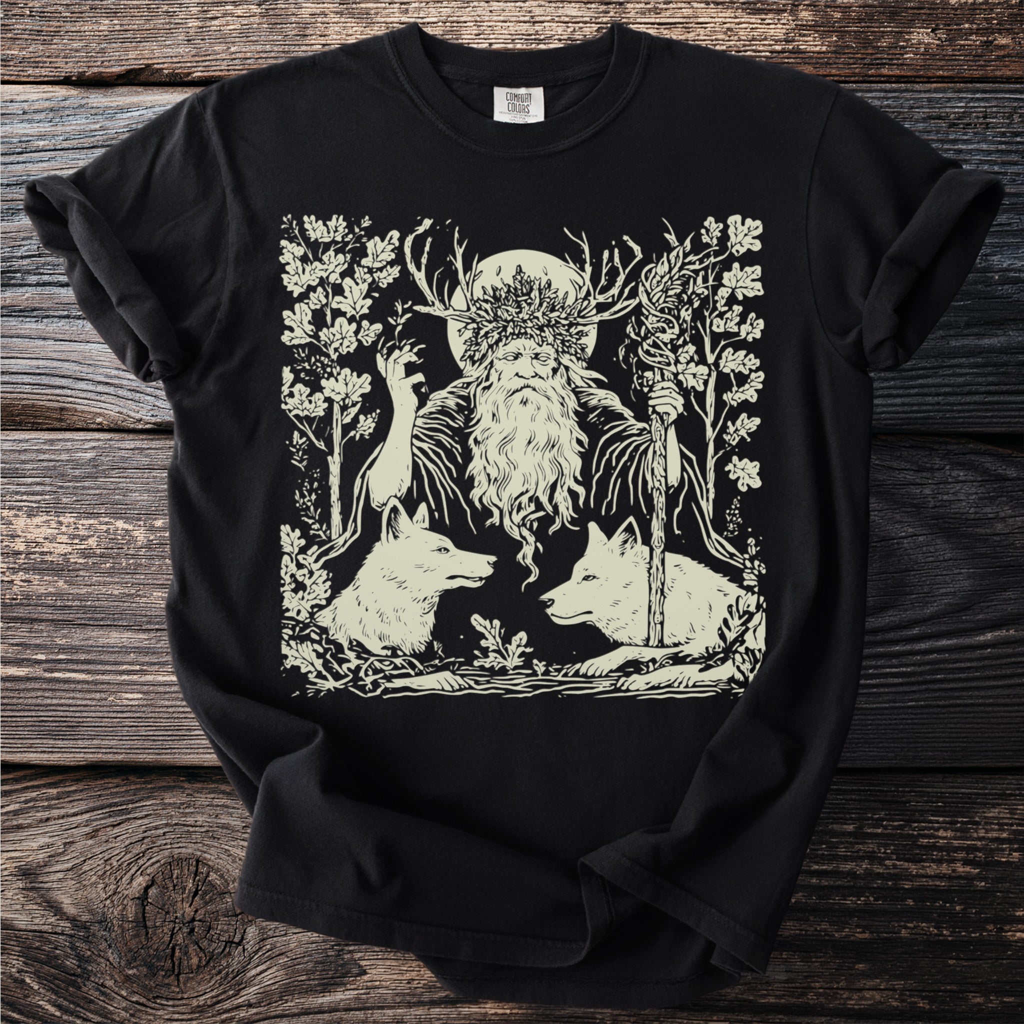 Black t-shirt with a cream linocut style print of a man with antlers and wolves.