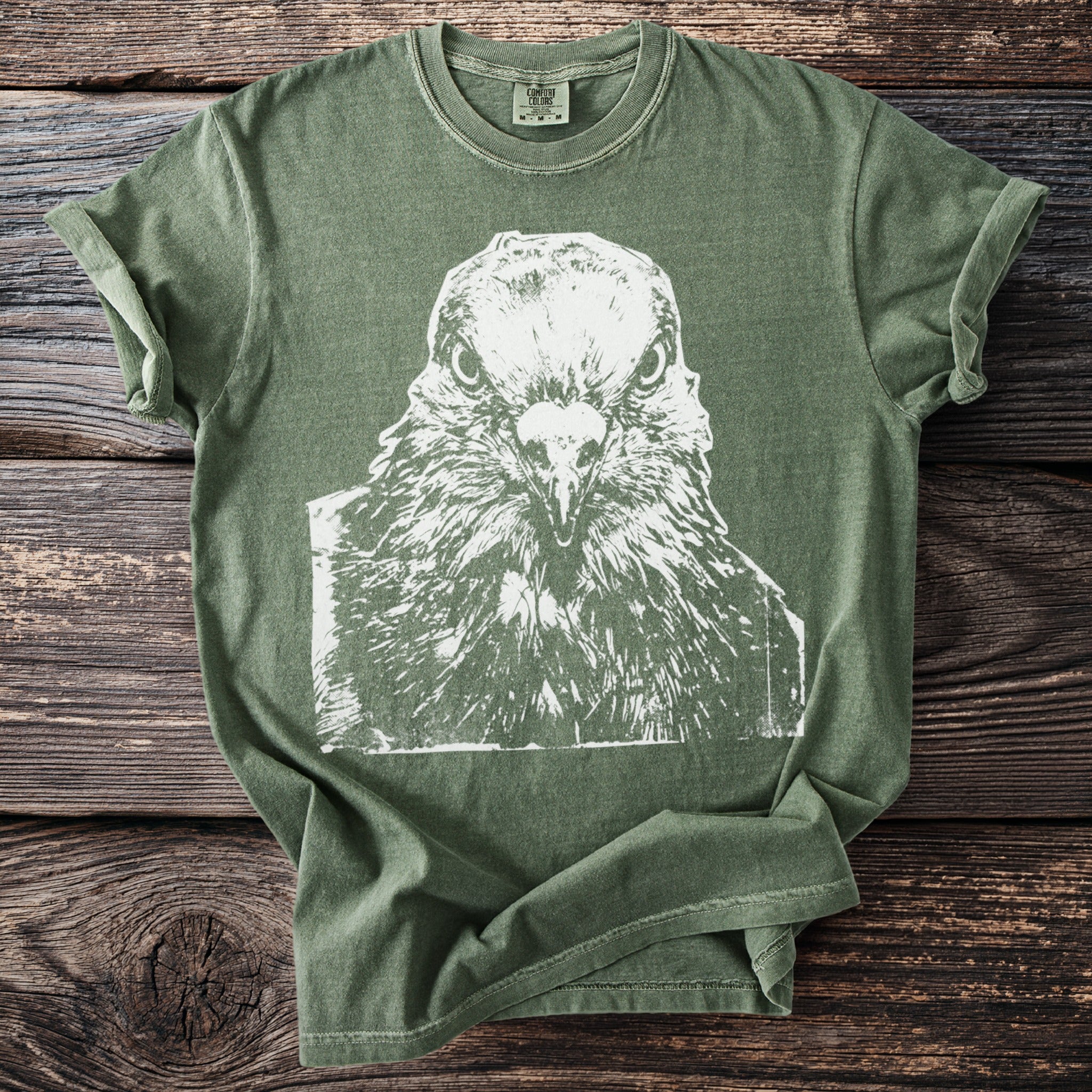 Green Comfort Colors t-shirt with white distressed graphic of a staring pigeon's face.