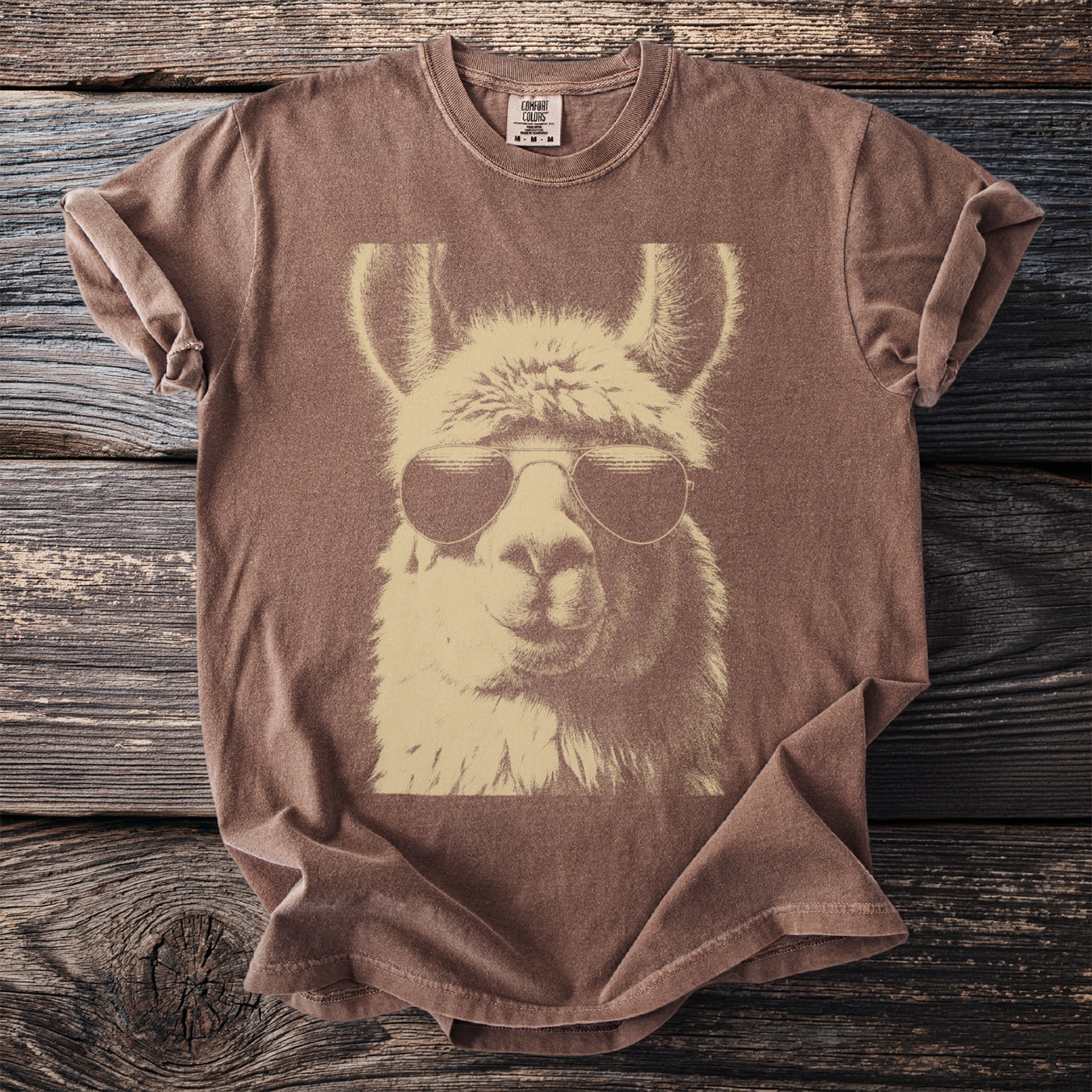 Brown t-shirt with a tan llama wearing aviator sunglasses graphic.