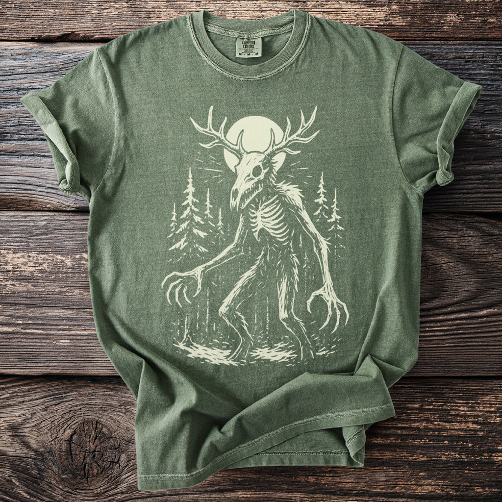 Green t-shirt with a distressed print of a skeletal creature with antlers in a forest.