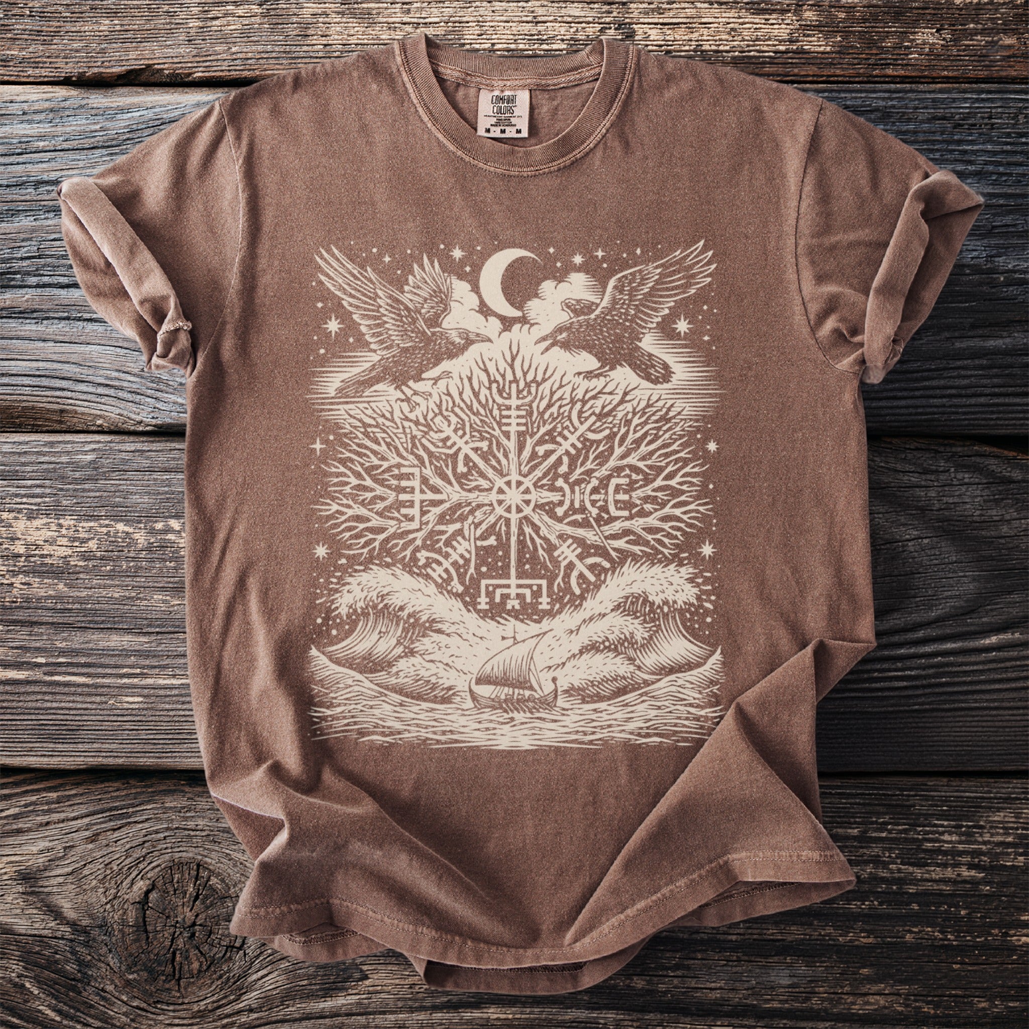 Brown t-shirt with graphic of raven-like birds, tree, moon, and viking ship.