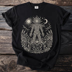 Black t-shirt with a cream linocut style print of a tree-like figure surrounded by nature scenes and figures.